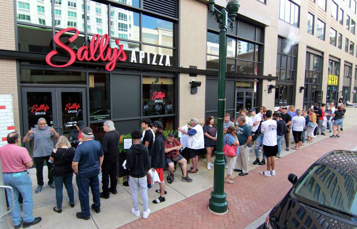 A crowd lines up down Summer Street waiting to enter Sally's Apizza in Stamford, Conn., on Thursday October 7, 2021. This is the new outpost of the beloved New Haven pizza restaurant.