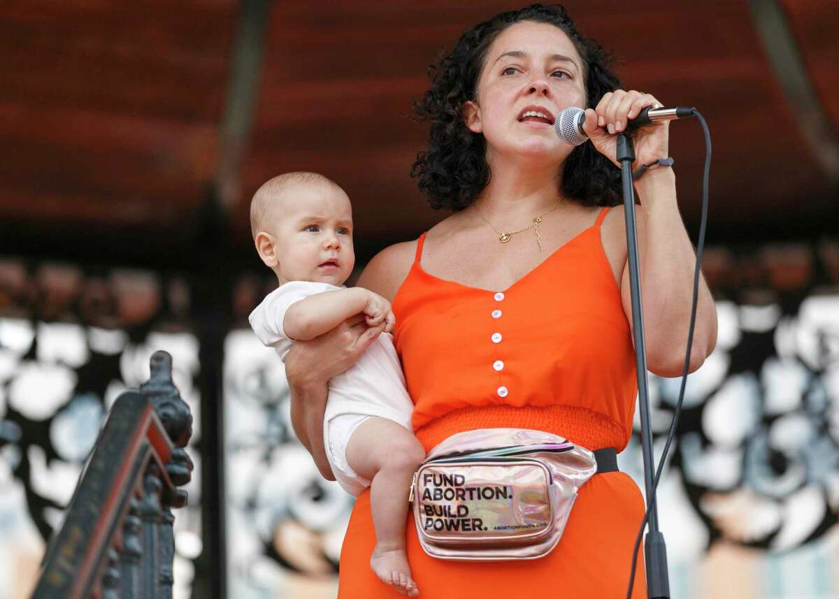 Ali Perez holds up her youngest child as she shares her personal experience with abortion during the “Ban Off Our Bodies” abortion rights rally at Milam Park in Downtown San Antonio, Texas, Saturday afternoon, Oct. 2, 2021. The mother of four said she used to be embarrassed to share that she had an abortion but thinks everyone should have the power to chose when and how they want to have children.