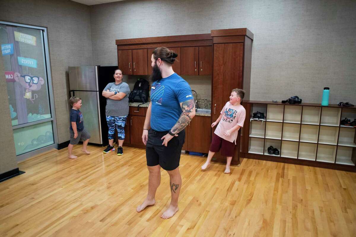 Trevor Peek talks with Danielle Goodspeed and her sons Bryson and Paxton after their workout class in Life Time on Friday, Sept. 24, 2021, in Cypress, Texas.