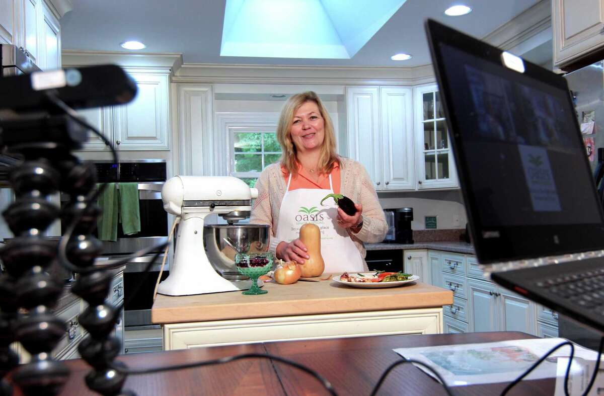 Susan Doyle, who uses Zoom to broadcast her show: Downsized Gourmet, poses in her kitchen at her home in Stamford, Conn., on Tuesday October 5, 2021. Due to the COVID-19 pandemic, in June of 2020 Susan and her husband Paul, who takes care of all things tech related, started the cooking show and invited members of several senior centers and facilities to tune in. Their work has culminated in a cookbook which will raise money for the Fairfield County Walk to End Alzheimer's slated for Sunday October 10th.