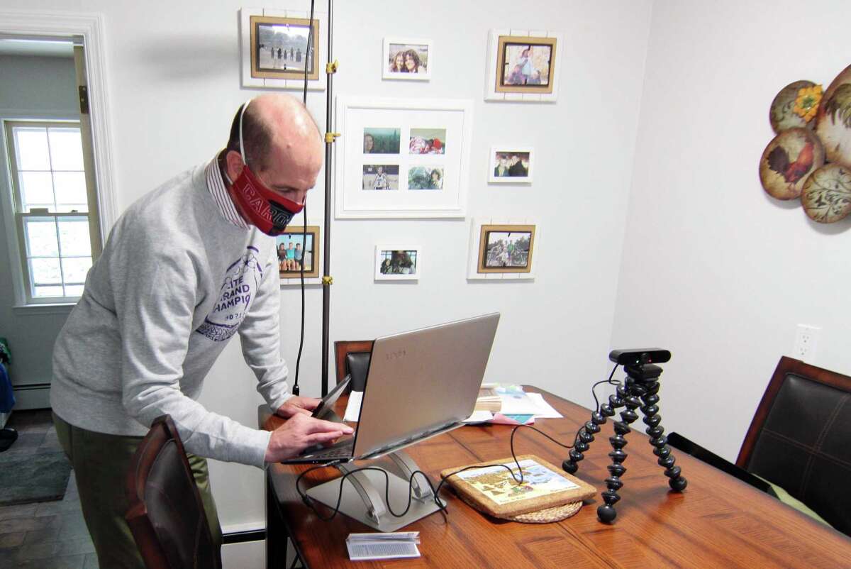 Paul Doyle, who helps his wife Susan use Zoom to broadcast her show: Downsized Gourmet, sets up equipment in the kitchen at their home in Stamford, Conn., on Tuesday October 5, 2021. Due to the COVID-19 pandemic, in June of 2020 Susan started the cooking show and invited members of several senior centers and facilities to tune in. Their work has culminated in a cookbook which will raise money for the Fairfield County Walk to End Alzheimer's slated for Sunday October 10th.