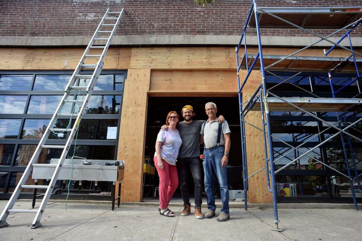 Owners Michele and Rick Torres stand with their son, John, center, the general manager of Park City Music, currently under construction in the former Acoustic Café space, in Bridgeport, Conn. Oct. 6, 2021.