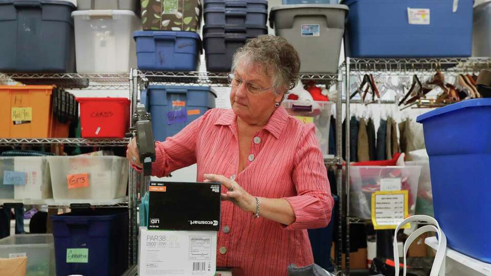 Karla Oubre, check recently donated items at the Interfaith of The Woodlands' Hand Me Up Shop, Thursday, Oct. 7, 2021, in Spring. The 10-year volunteer used various genealogy sites to help track down the families of several antique book donated to The Woodlands non-profit.