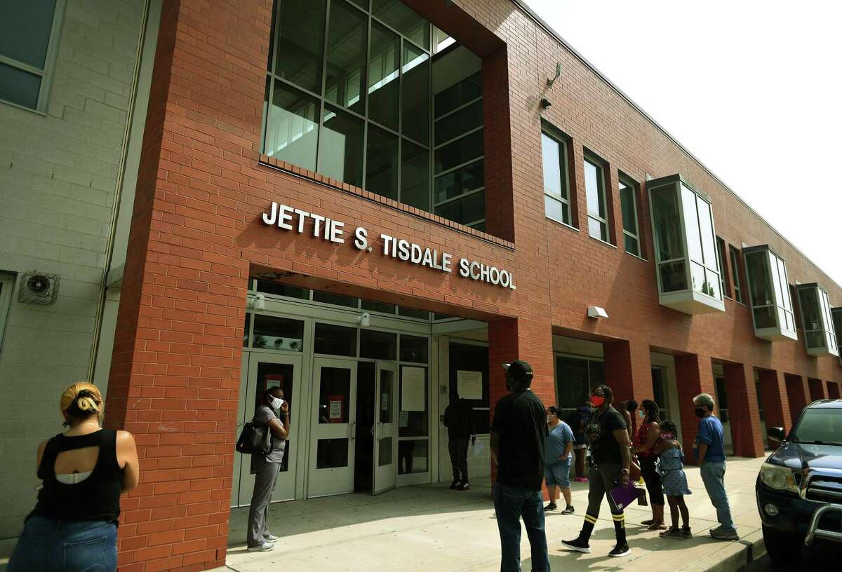 Parents wait outside Jettie S. Tisdale School to be distributed laptops for at home learning in Bridgeport, Conn. on Monday, September 14, 2020. The school is closed for one week after staff tested positive for Covid-19.
