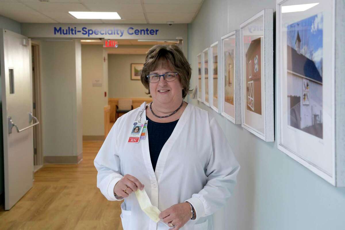 Barbara Davies, Director of Patient Care Services, New Milford Hospital with an exhibit of photographs from the Barn Quilt Trail, in New Milford, in the hospitals new repurposed wing. Friday, October 8, 2021, in New Milford.