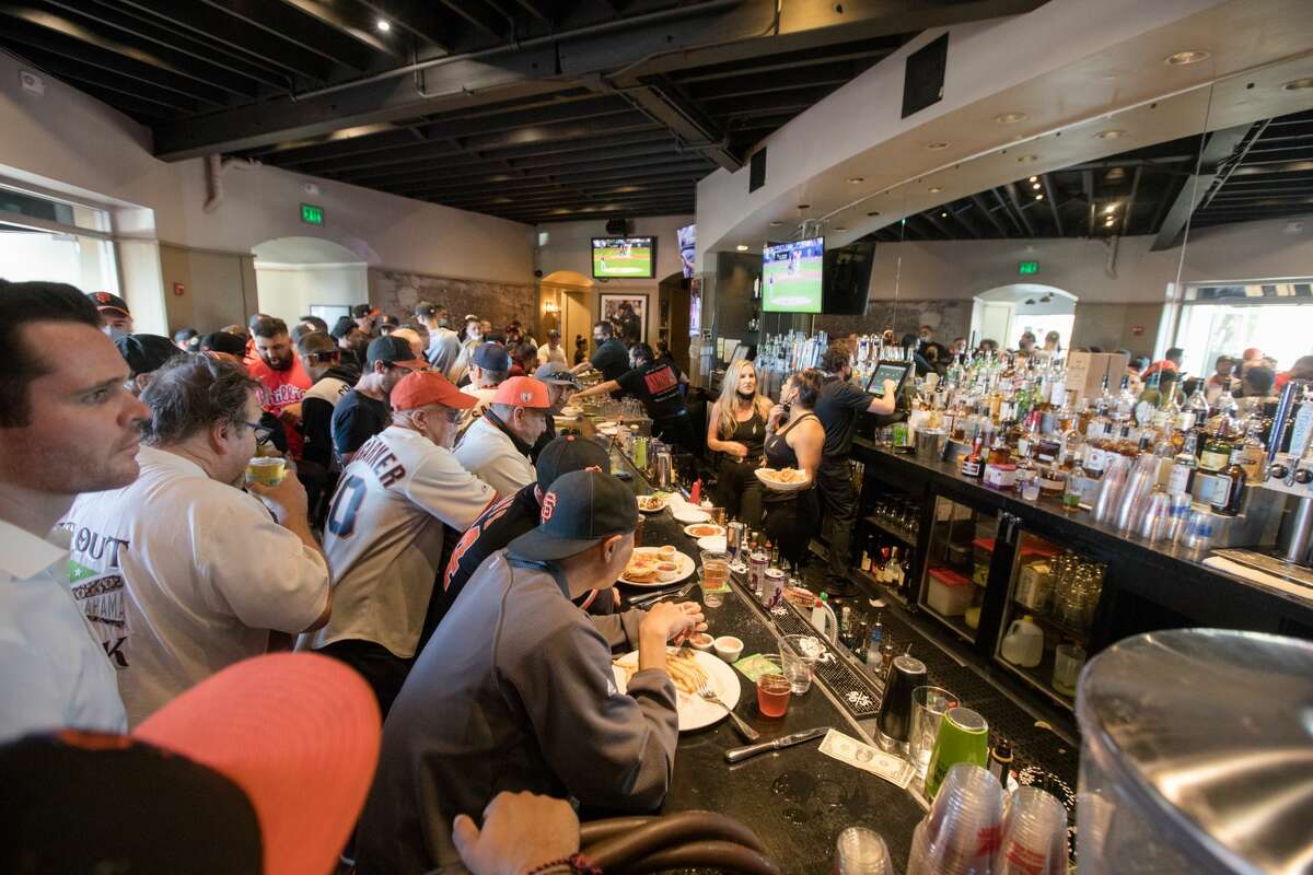 San Francisco Giants fans sit at the bar at MoMo's, a sports bar and restaurant that sits across the street from Oracle Park in San Francisco, on Oct. 8, 2021, before Game 1 of the National League Division Series.