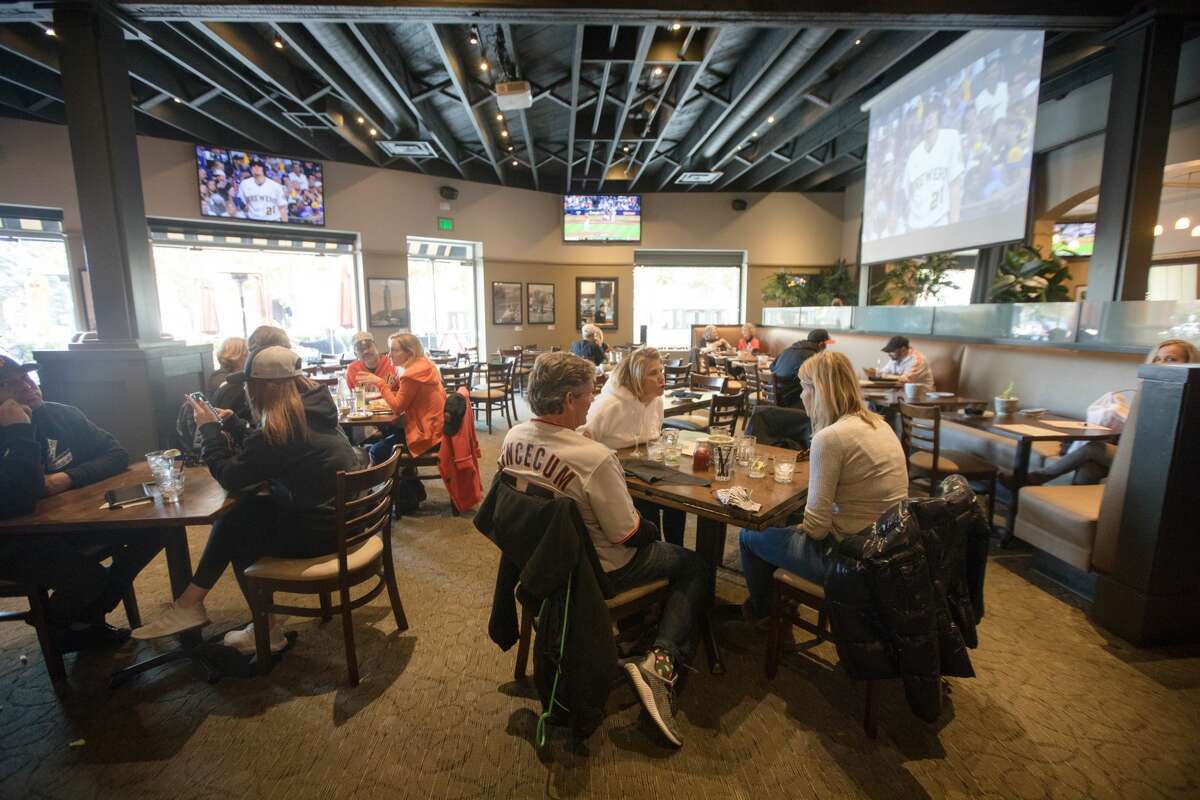 Giants fans enjoy a pre-game meal at MoMo's, a sports bar and restaurant across from Oracle Park in San Francisco on October 8, 2021.
