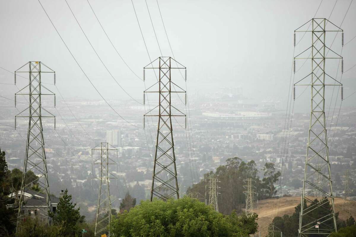 Smoke obscures the view behind transmission power lines in Oakland Hills, Oakland, California on August 18, 2021. PG&E has warned that customers in East and North Bay may see power outages starting Monday, October 11 due to dry winds and the risk of fires .