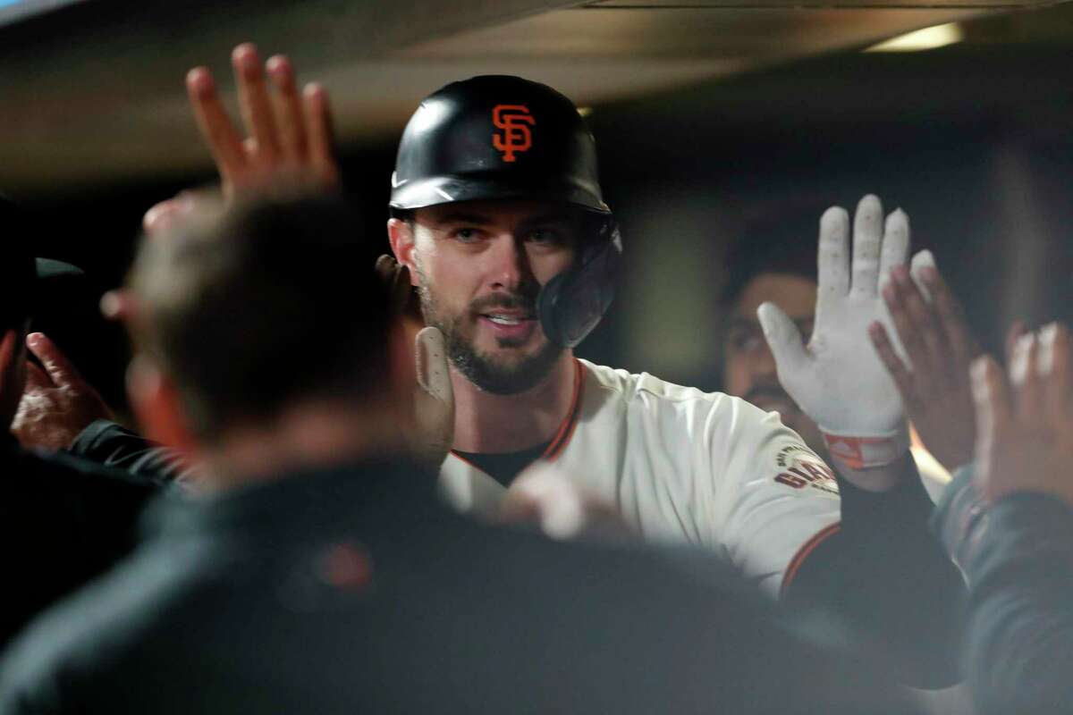 San Francisco Giants' Kris Bryant gets high fives in the dugout after his solo home run in 7th inning against Los Angeles Dodgers' Walker Buehler during National League Division Series Game 1 at Oracle Park in San Francisco, Calif., on Friday, October 8, 2021