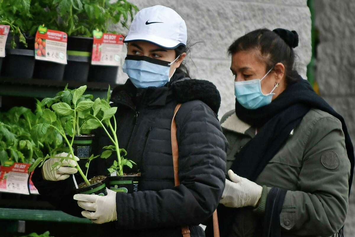 Local residents wear masks against contracting the coronavirus as ordered by the governor Tuesday, April 21, 2020, in Norwalk, Conn.