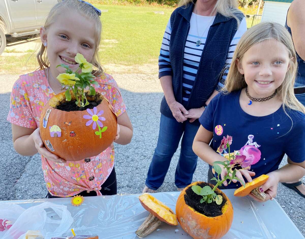 Jozie Skiera and Emmie Skiera proudly show their decorated pumpkins that also house plants inside. 