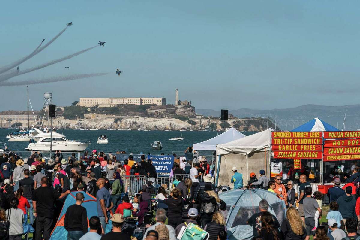 The U.S. Navy Blue Angels break formation over Alcatraz Island as spectators at Marina Green watch the Air Show at Fleet Week in San Francisco. The event contributed to a busy weekend as more people used public transit services than any previous time during the pandemic.