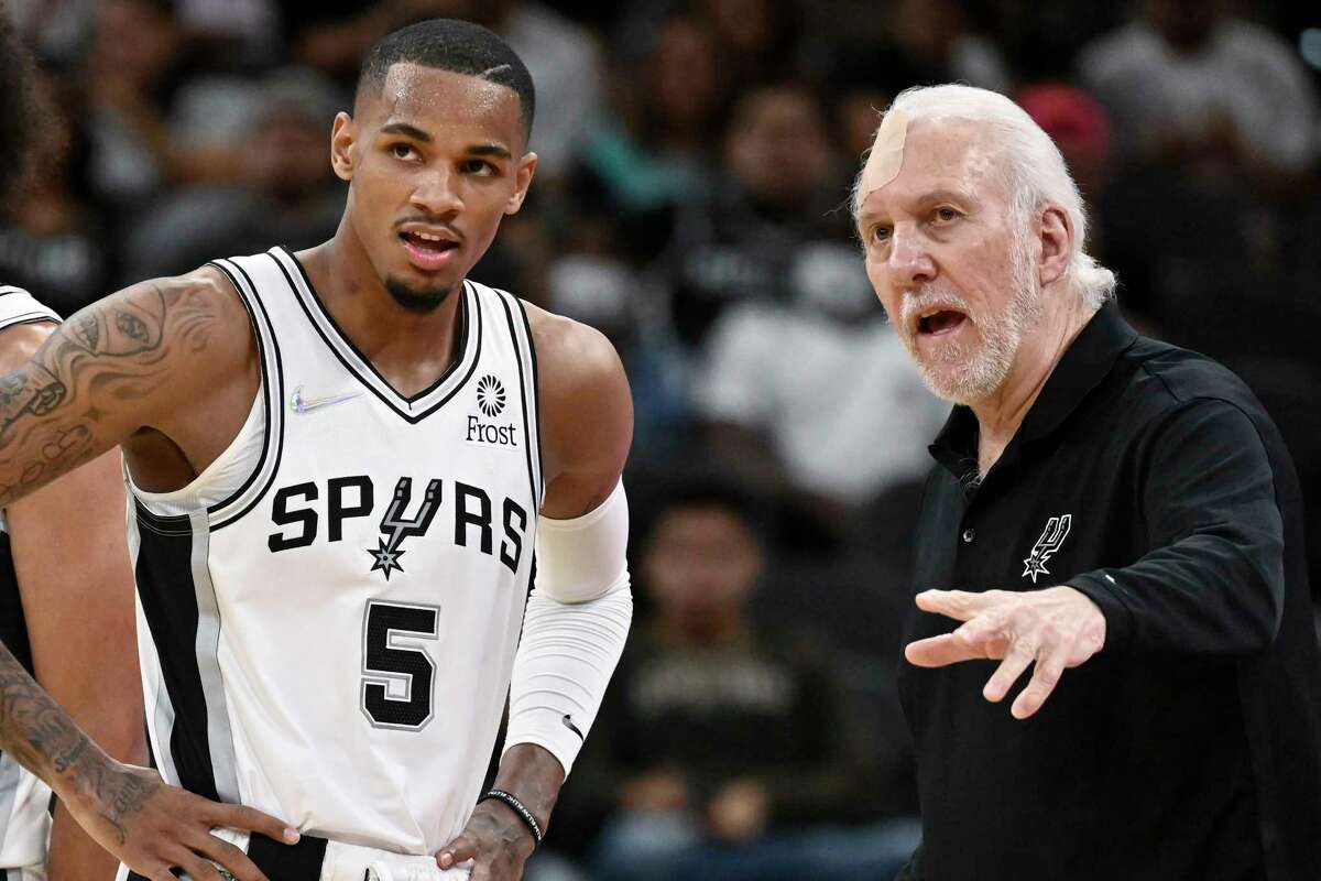 San Antonio Spurs head coach Gregg Popovich, right, talks with Spurs guard Dejounte Murray during the second half of a preseason NBA basketball game against the Miami Heat, Friday, Oct. 8, 2021, in San Antonio.