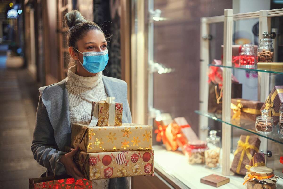 Pictured is a woman walking and shopping Christmas gifts in the city.