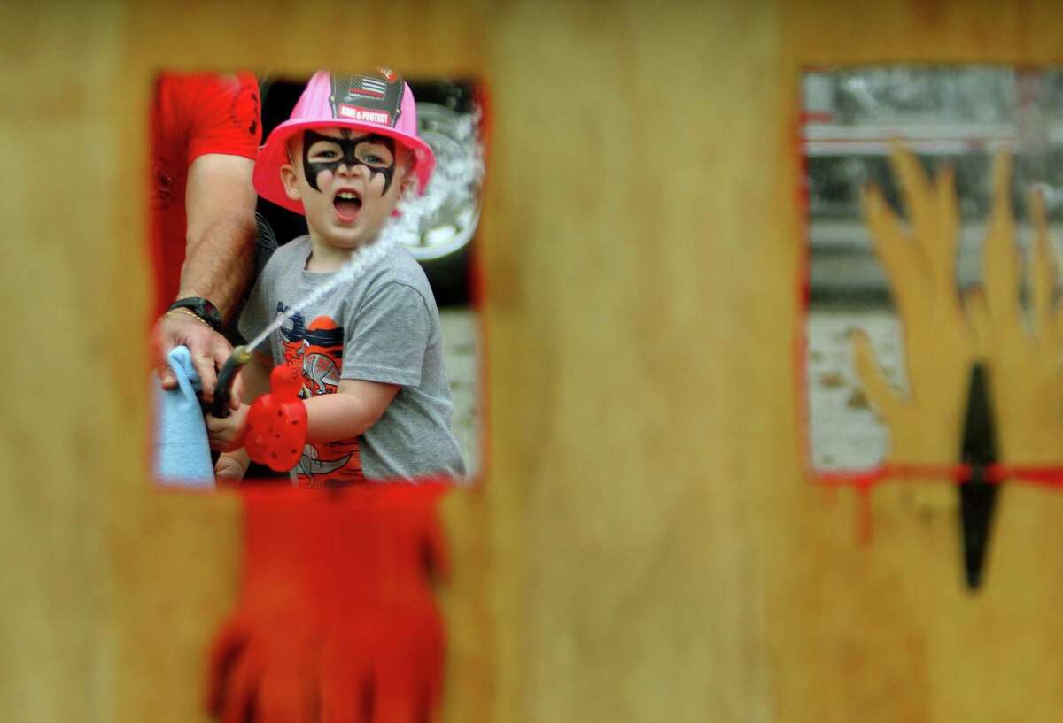 Landon Bova, 3, uses a water supplied fire extinguiser to try an knock over "flames" during Huntington Fire Company No. 3's first ever fire prevention event on Saturday. A variety of activities were available for kids to take part in. Kids learned valuable fire safety tips from department firefighters, got a close up view of life-saving equipment and face paintings to name just a few.
