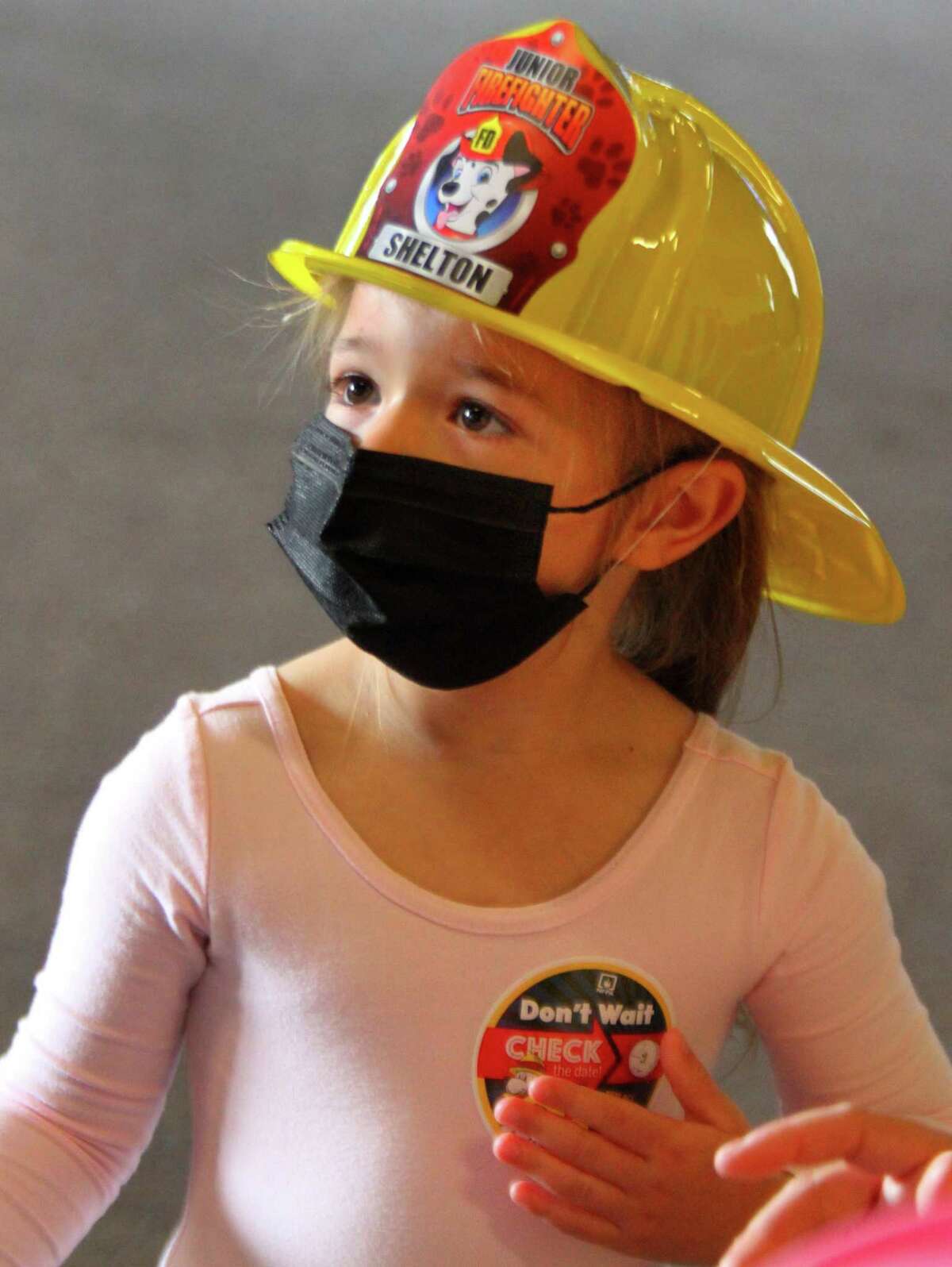 In photos clockwise from above, Juliana Prete, 3, gets a sticker and fire helmet during Huntington Fire Company No. 3's fire prevention event in Shelton on Saturday. In a drill on Saturday, firefighter Jeff Daniels teaches MacKenzie Lougal, 4, to "Get down and get out" in case of fire. Kelly McClinch Pineau paints the face of Andrew Fittante, 9, during the event. Joseph Fittante, 11, and his sister Giovanna, 4, spray water from extinguishers as they attempt to put out a simulated fire during a drill on Saturday. Children at the prevention event learned valuable fire safety tips from firefighters, got a close up view of life-saving equipment and got face paintings.