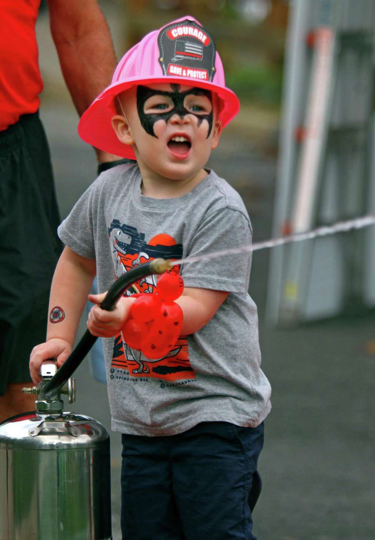 Landon Bova, 3, uses a water supplied fire extinguiser to try an knock over "flames" during Huntington Fire Company No. 3's first ever fire prevention event in Shelton, Conn., on Saturday October 9, 2021. A variety of activities were available for kids to take part in. Kids learned valuable fire safety tips from department firefighters, got a close up view of life-saving equipment and face paintings to name just a few.