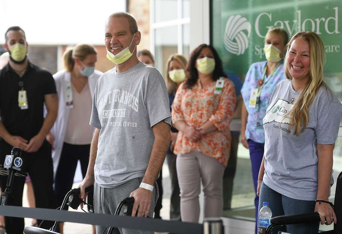Florida resident Robby Walker smiles as he thanks staff during his release from Gaylord Hospital and Covid-19 treatment in Wallingford, Conn. on Wednesday, October 13, 2021. Walker received ECMO treatment at St. Francis Hospital in Hartford, where the patient's blood is oxygenated outside the body to help the lungs in recovery. At right is Walker's wife, Susan Walker, who's plea on CNN lead to her husband's treatment in Connecticut.