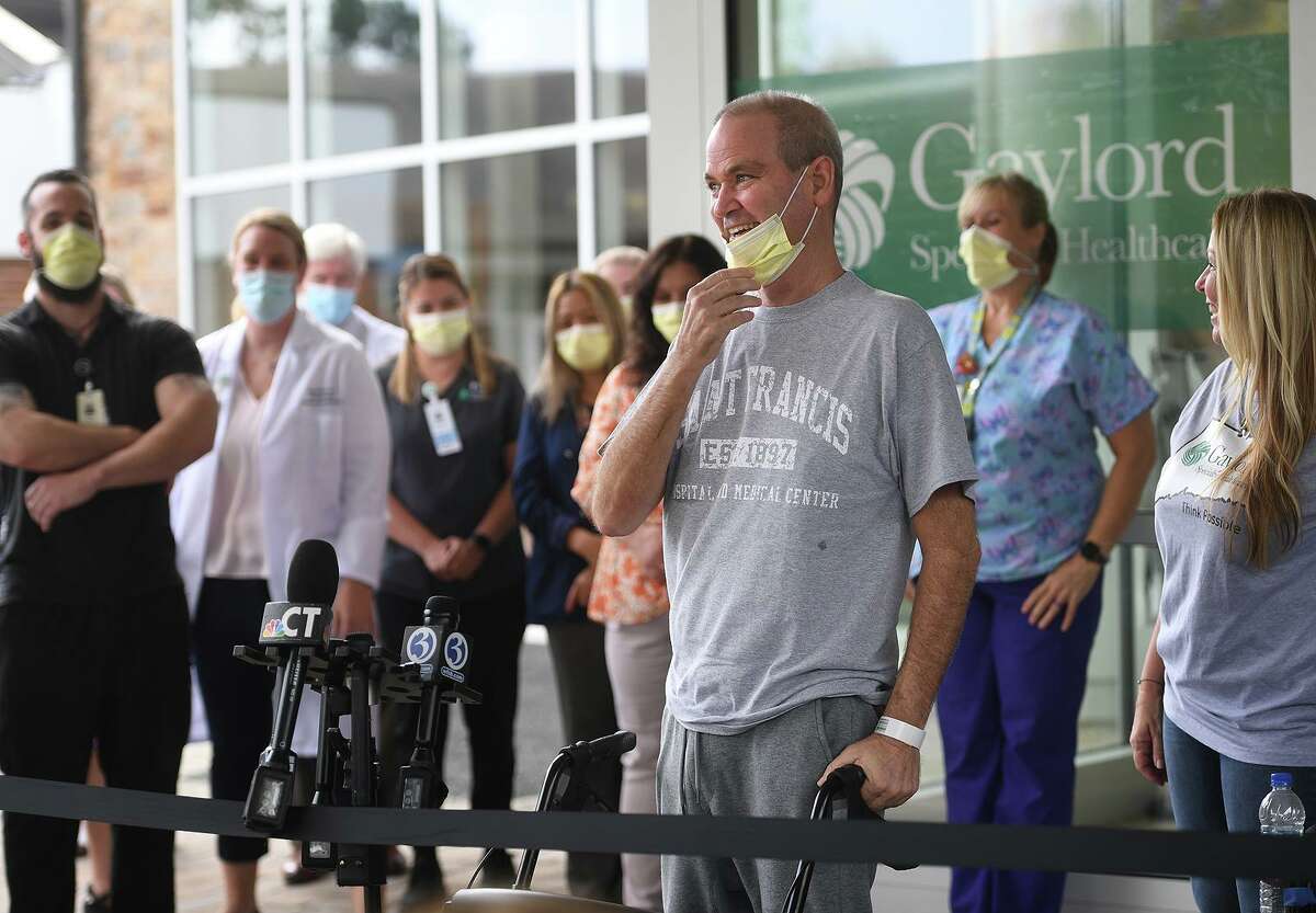 Florida resident Robby Walker smiles as he thanks staff during his release from Gaylord Hospital and Covid-19 treatment in Wallingford, Conn. on Wednesday, October 13, 2021. Walker received ECMO treatment at St. Francis Hospital in Hartford, where the patient's blood is oxygenated outside the body to help the lungs in recovery. At right is Walker's wife, Susan Walker, who's plea on CNN lead to her husband's treatment in Connecticut.
