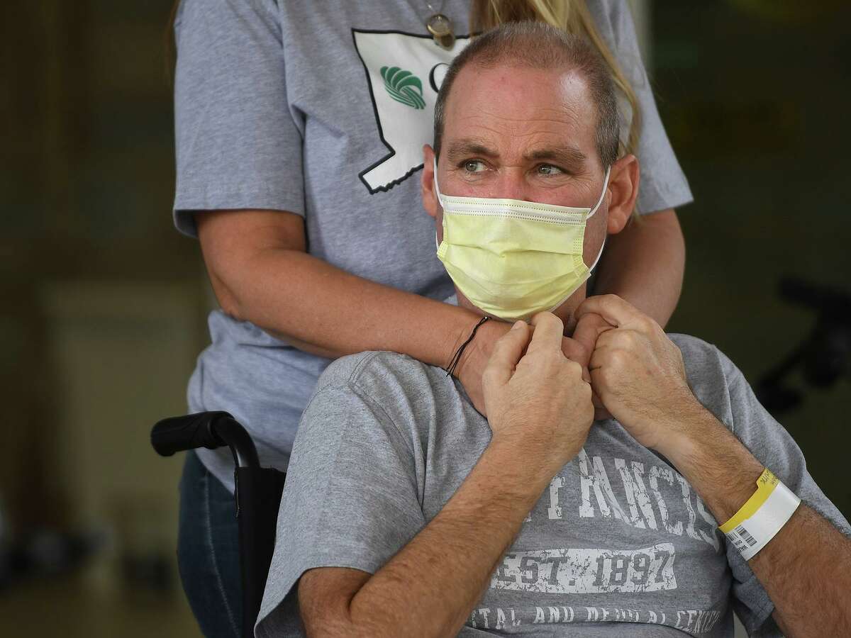 In the arms of his wife, Susan, Florida resident Robby Walker is released from Gaylord Hospital and Covid-19 treatment in Wallingford, Conn. on Wednesday, October 13, 2021. Walker received ECMO treatment at St. Francis Hospital in Hartford, where the patient's blood is oxygenated outside the body to help the lungs in recovery.
