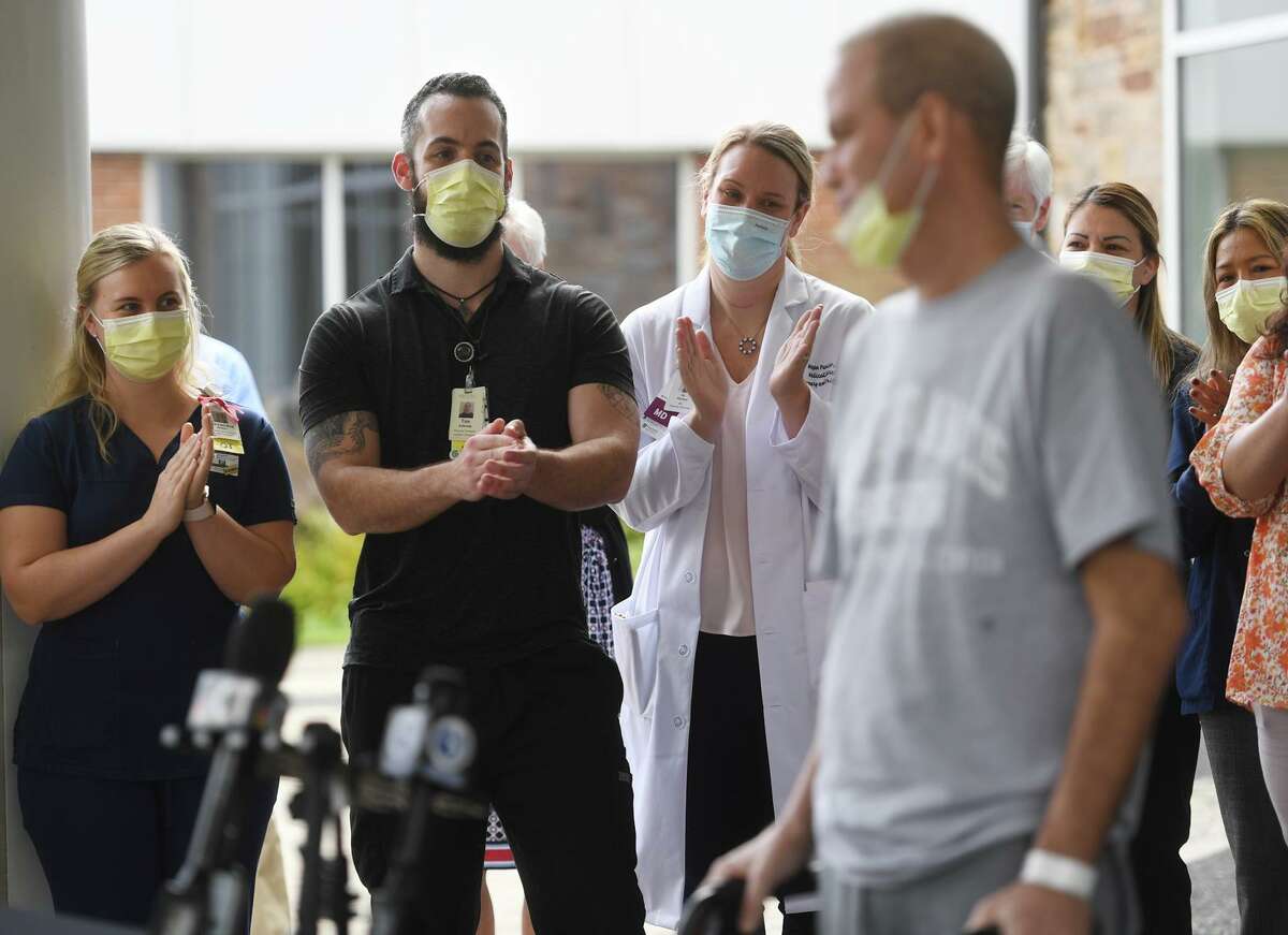 Medical staff applaud the release of Florida resident Robby Walker from Covid-19 rehabilitation at Gaylord Hospital in Wallingford, Conn. on Wednesday, October 13, 2021.