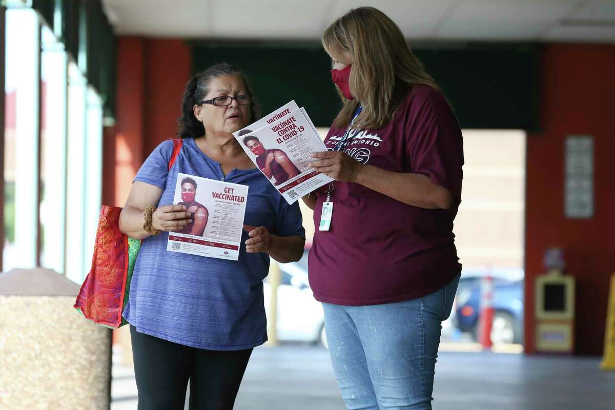 San Antonio Metropolitan Health District workers, Mikela Villarreal, right, gives Marta Munoz, information about upcoming free COVID-19 vaccination events, as district personnel worked the area around Las Palmas Shopping Center, Friday, Aug. 6, 2021.