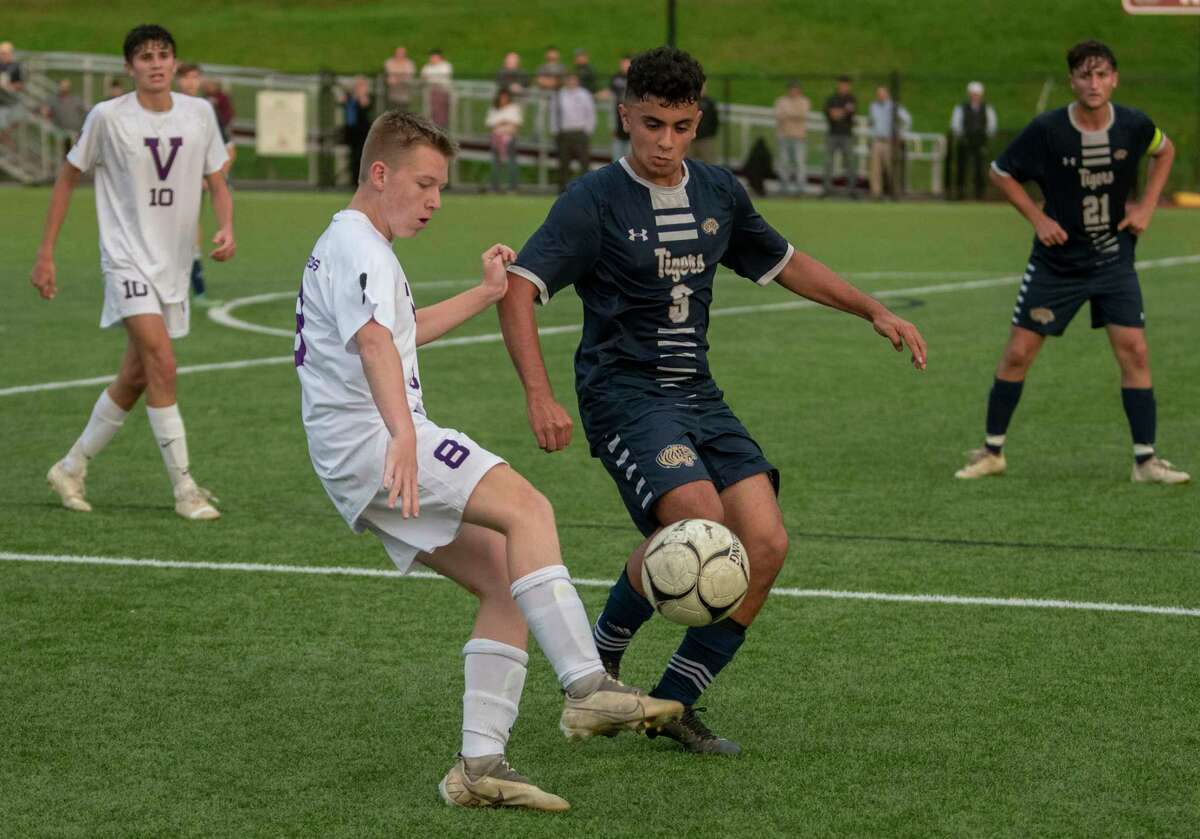 Voorheesville's Jake Johnson, left, kicks the ball past Cohoes' Johnny Martinez-Peraza during the Colonial Council tournament boys' soccer game on Wednesday, Oct, 13, 2021 in Troy, N.Y.