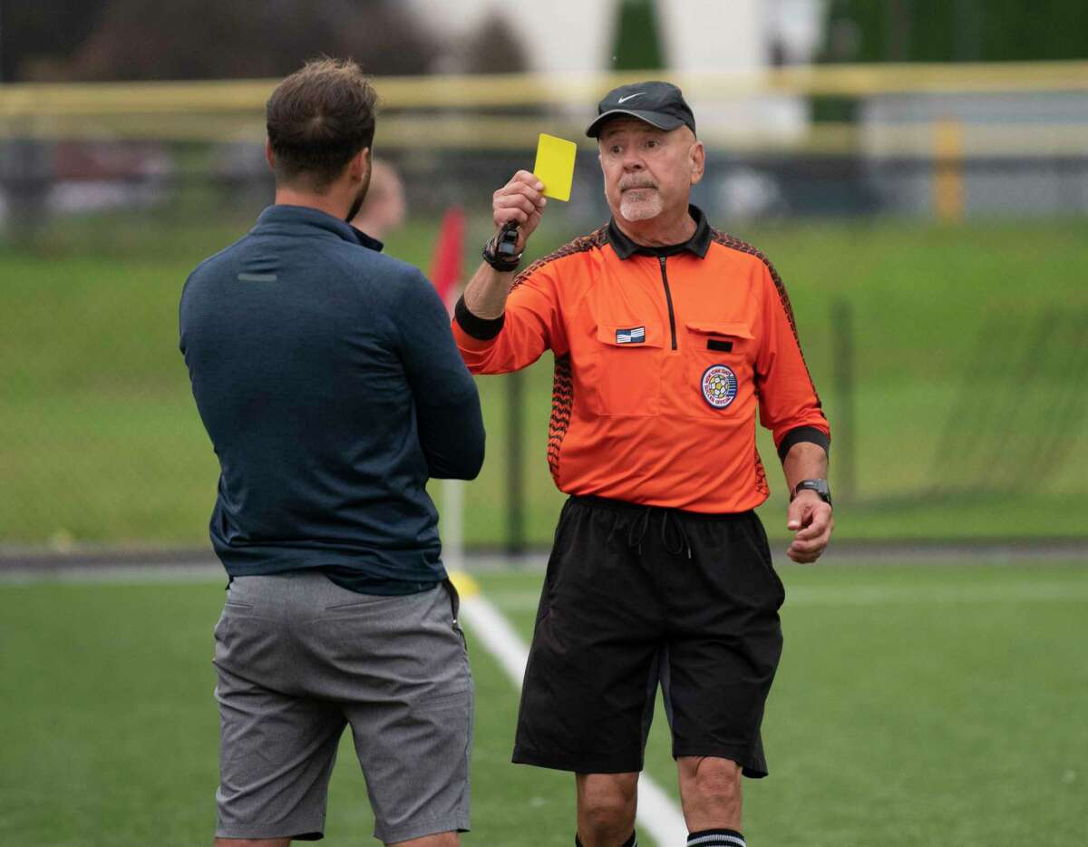 Cohoes head coach Nick Izzo is seen getting a yellow card from an official during the Colonial Council tournament boys' soccer game against Voorheesville on Wednesday, Oct, 13, 2021 in Troy, N.Y.