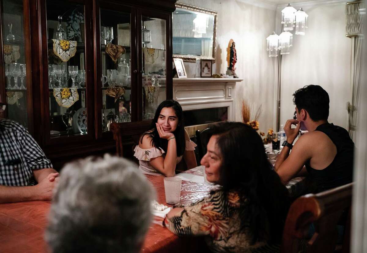 Eighteen-year-old Jessica Ramos listens to her family speak at the dinner table at her grandmother’s home in Hayward.