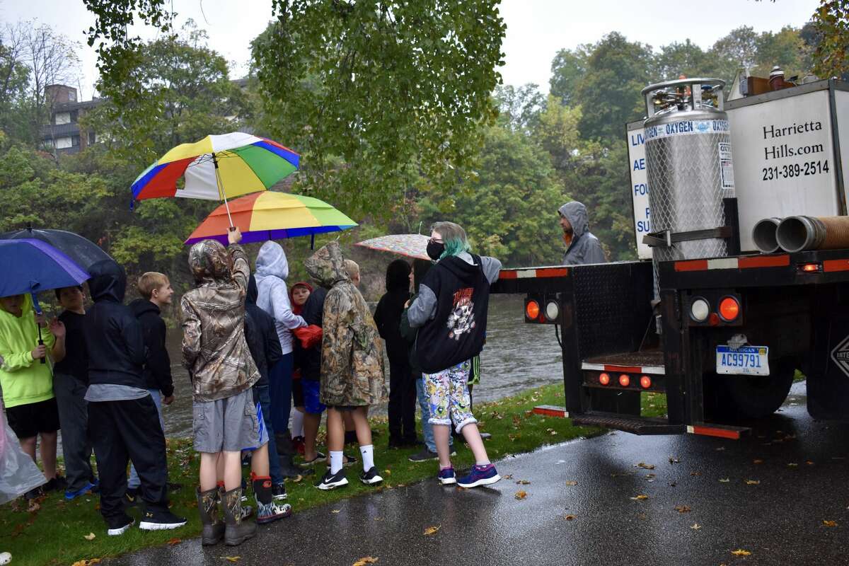 On Oct. 14, students from Big Rapids Middle School helped Harrietta Hills Trout Farm release young fish into the Muskegon River using buckets. 