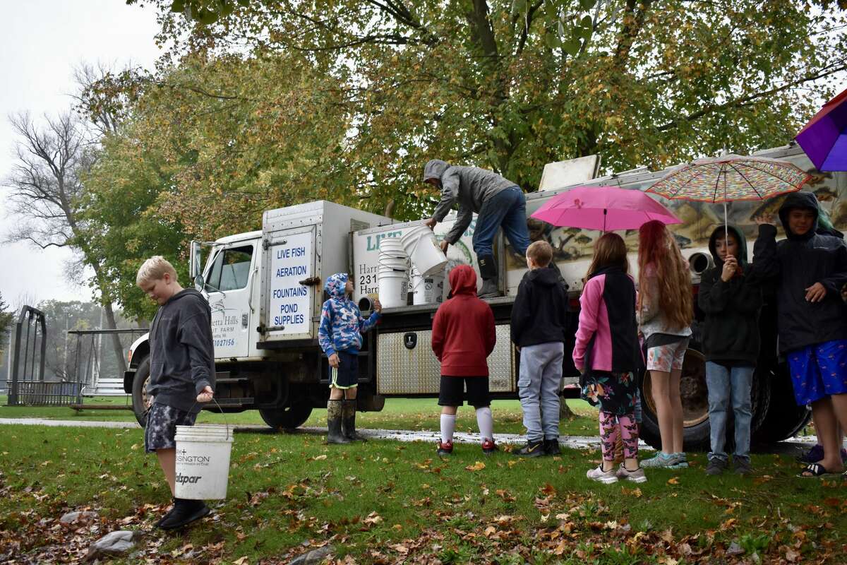 On Oct. 14, students from Big Rapids Middle School helped Harrietta Hills Trout Farm release young fish into the Muskegon River using buckets.