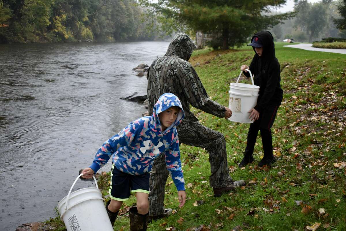 On Oct. 14, students from Big Rapids Middle School helped Harrietta Hills Trout Farm release young fish into the Muskegon River using buckets.