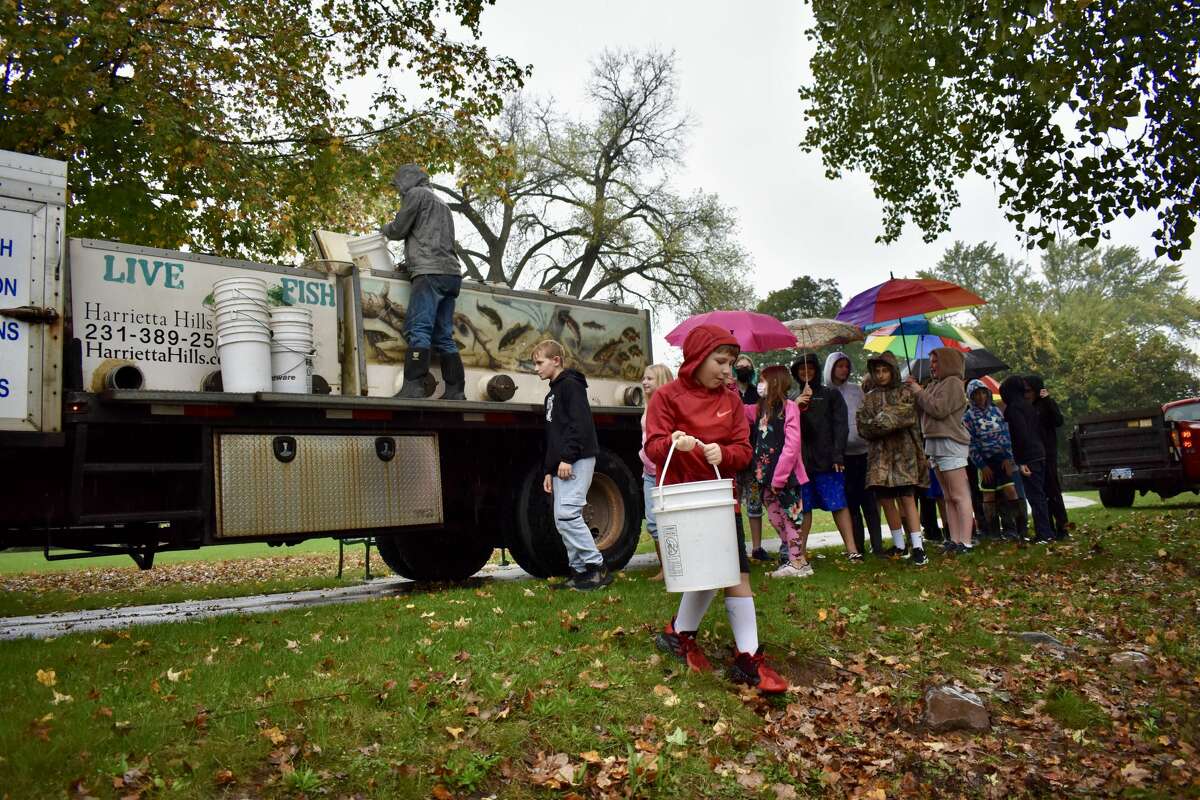 On Oct. 14, students from Big Rapids Middle School helped Harrietta Hills Trout Farm release young fish into the Muskegon River using buckets.