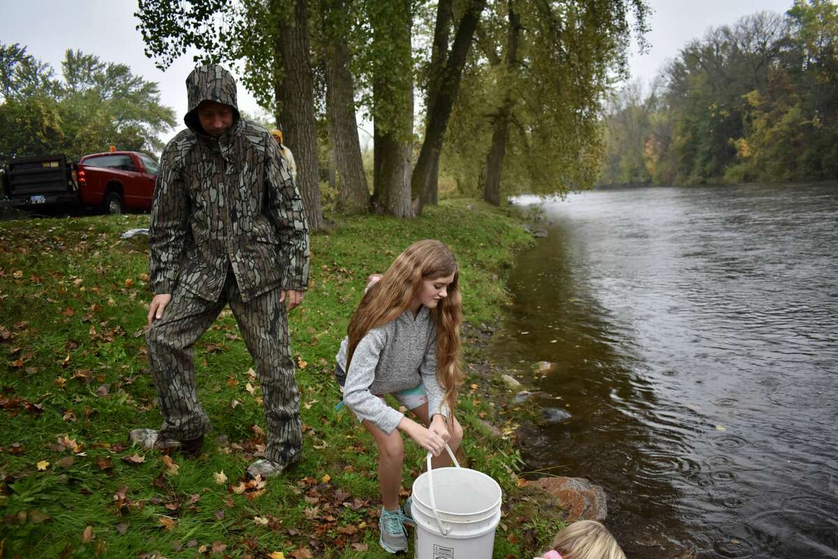 On Oct. 14, students from Big Rapids Middle School helped Harrietta Hills Trout Farm release young fish into the Muskegon River using buckets.