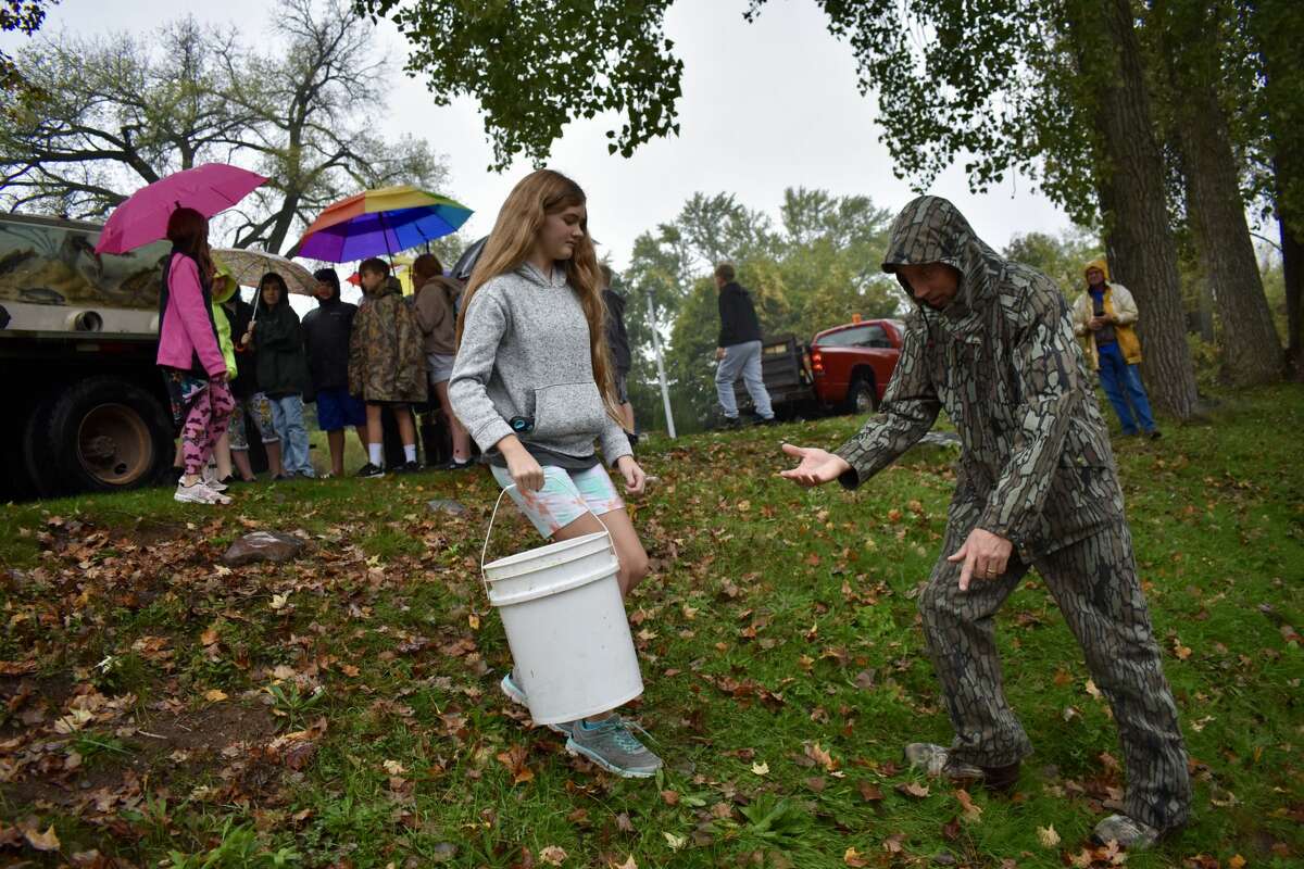 On Oct. 14, students from Big Rapids Middle School helped Harrietta Hills Trout Farm release young fish into the Muskegon River using buckets.
