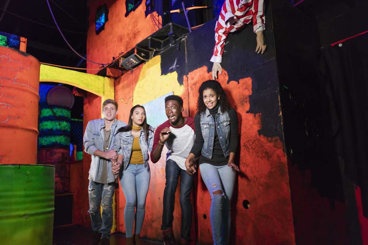Pictured is a group of young adults having fun in a halloween haunted house.