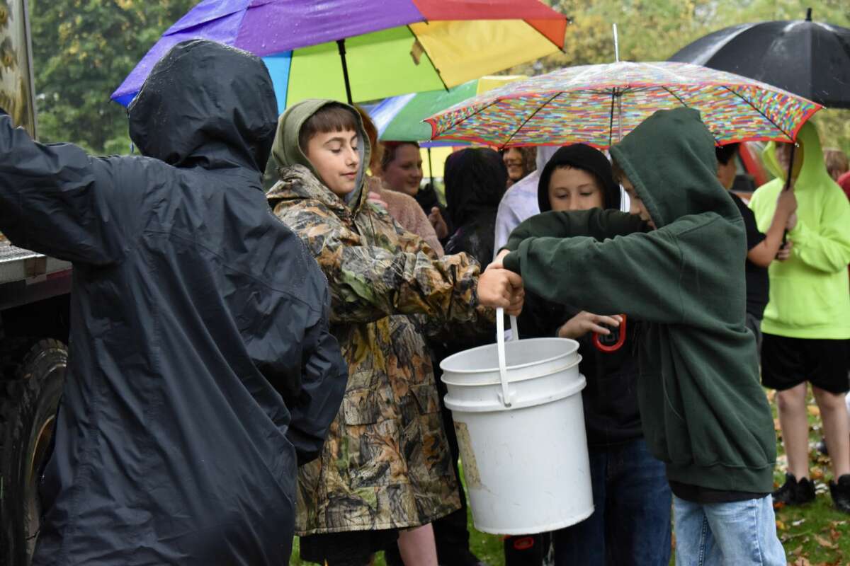 On Oct. 14, students from Big Rapids Middle School helped Harrietta Hills Trout Farm release young fish into the Muskegon River using buckets.
