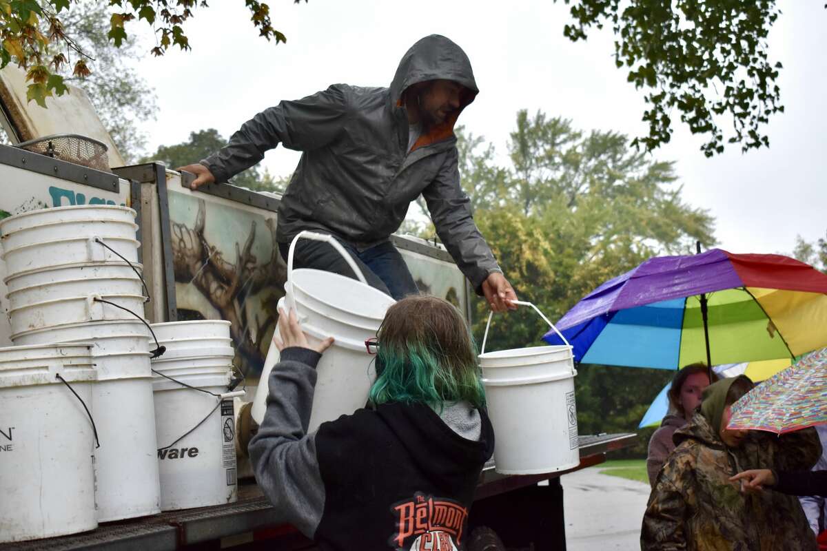 On Oct. 14, students from Big Rapids Middle School helped Harrietta Hills Trout Farm release young fish into the Muskegon River using buckets.