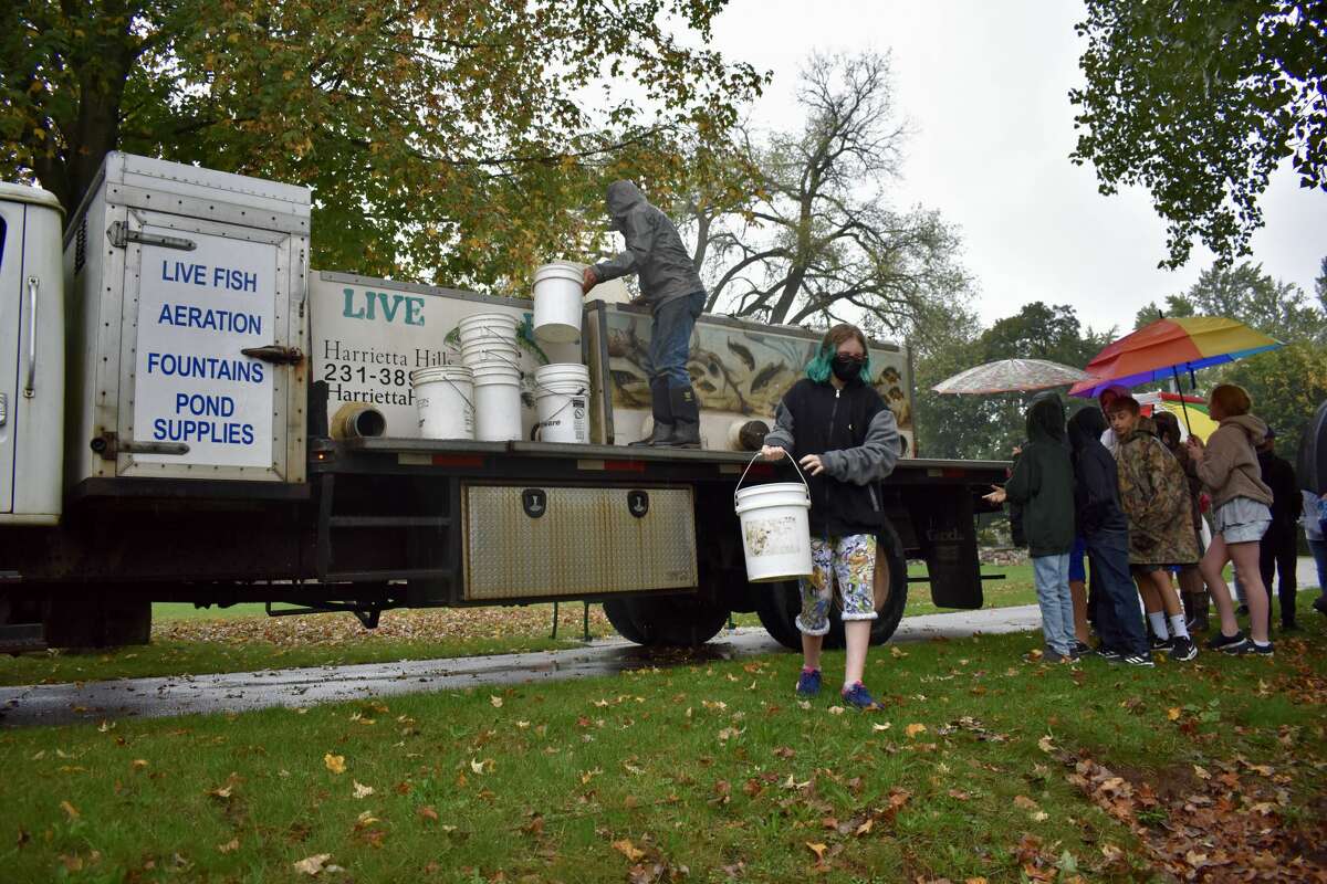 On Oct. 14, students from Big Rapids Middle School helped Harrietta Hills Trout Farm release young fish into the Muskegon River using buckets.