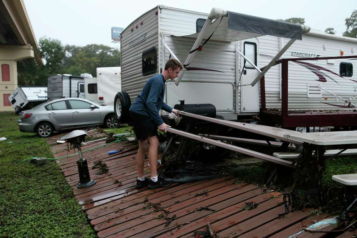 Austin McGhee, 17, helps clean up by his family’s recreational vehicle at the River Ranch RV Resort in New Braunfels, Texas, Thursday, Oct. 14, 2021. Heavy rains from Tropical Storm Pamela flooded Guadalupe River overnight. One RV was swept away by the high waters and several others were damaged. Some places in the area received over 5 and a half inches of rain according to CoCoRaHS.