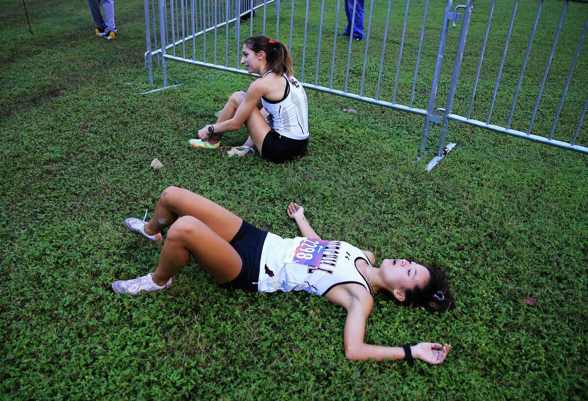 Churchill's Ashley Moore (foreground) shows exhaustion beside teammate Danielle Peck after they competed in the District 28-6A cross country championships at North East Sports Park on Thursday, Oct. 14, 2021. Peck took first place and Moore finished in second in the girls' varsity race.