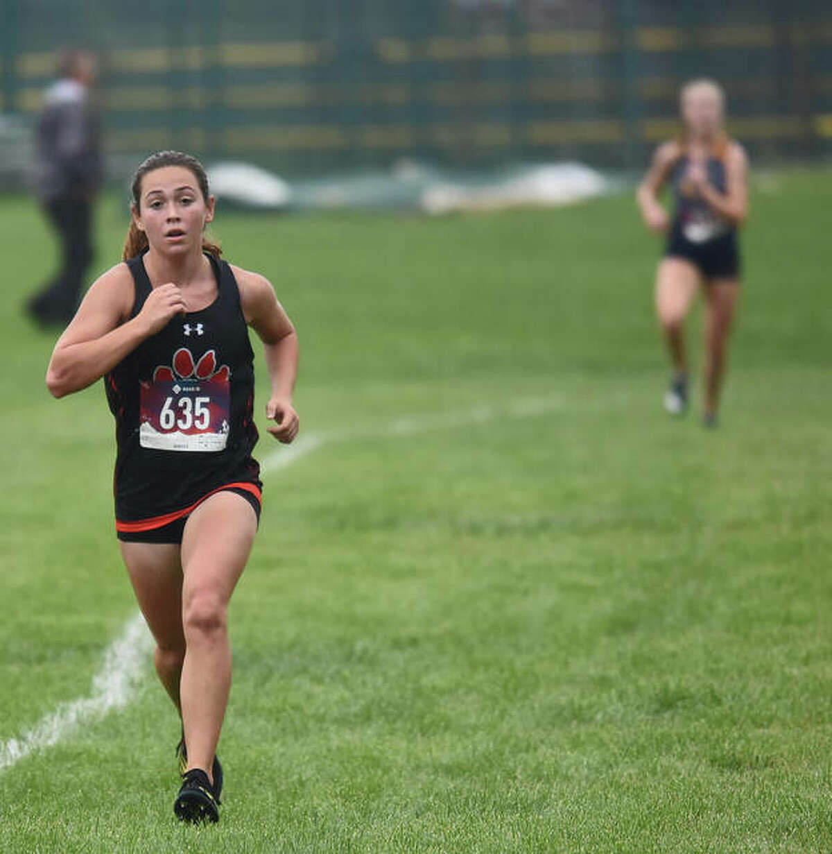 Edwardsville’s Olivia Coll, left, breaks away from an O’Fallon runner on a straightaway during the Southwestern Conference Meet.