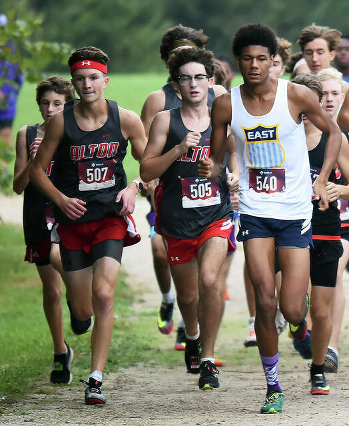 Alton’s Victory Humphrey, left and Dylan Forsythe, center, jockey for position with Belleville East’s Byron Jones at Thursday’s Southwestern Conference boys cross country meet in Belleville
