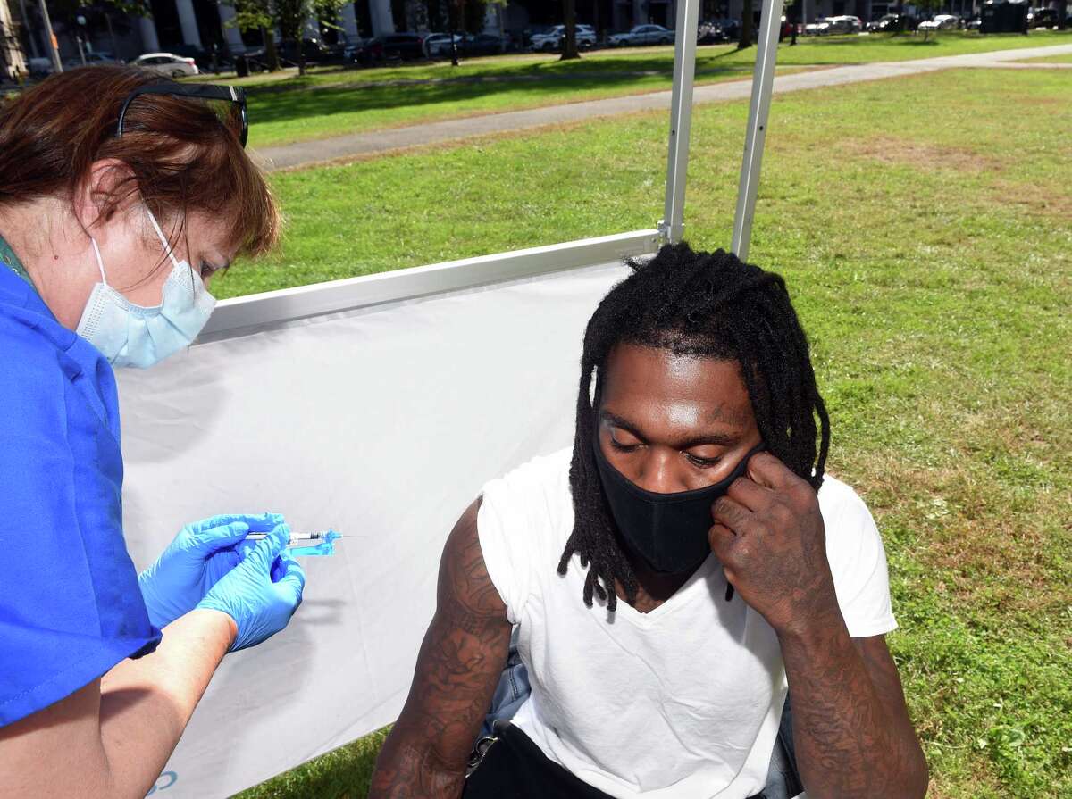 Griffin Hospital RN Laurice Masek (left) gives Christopher Graham of New Haven his second dose of the Pfizer COVID-19 vaccine at a vaccine clinic on the New Haven Green on October 15, 2021.