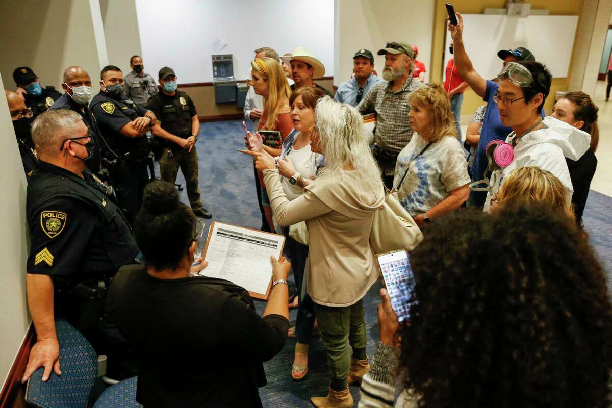 Opponents of mask mandates argue to be let into a Dallas ISD school board meeting closed session on Thursday, Aug. 26, 2021, in Dallas. (Elias Valverde II/The Dallas Morning News)