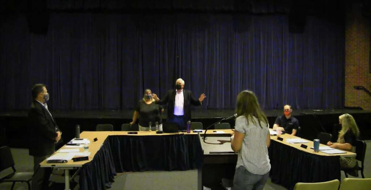 Brookfield's school board meeting was disrupted in mid-September by community members who were against COVID-19 protocols. Bob Belden, vice chairman of the school board member, is pictured in the center with his hands raised as a woman tries to speak at the podium after the meeting had been adjourned.