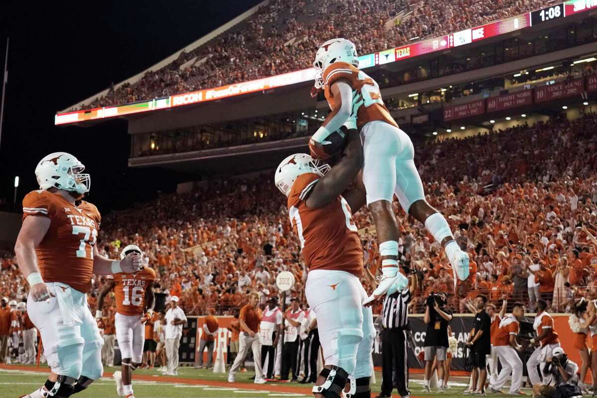 Texas running back Jonathon Brooks (24) is lifted by Tope Imade (67) after his touchdown against Rice during the second half of an NCAA college football game Saturday, Sept. 18, 2021, in Austin, Texas. (AP Photo/Chuck Burton)