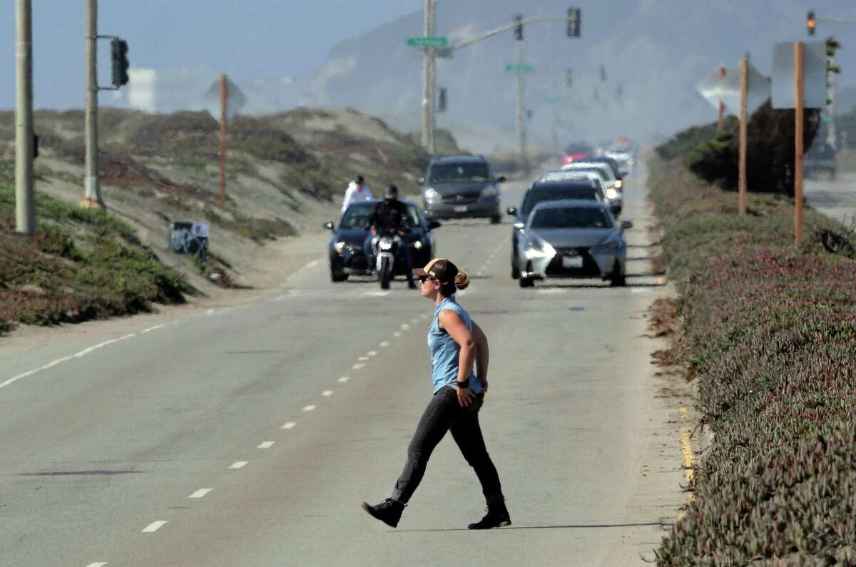 A woman crosses the Great Highway, which reopened to car traffic in San Francisco, in August 2021. A judge has ruled the city had the right to close roadways, including the Great Highway, during the pandemic.