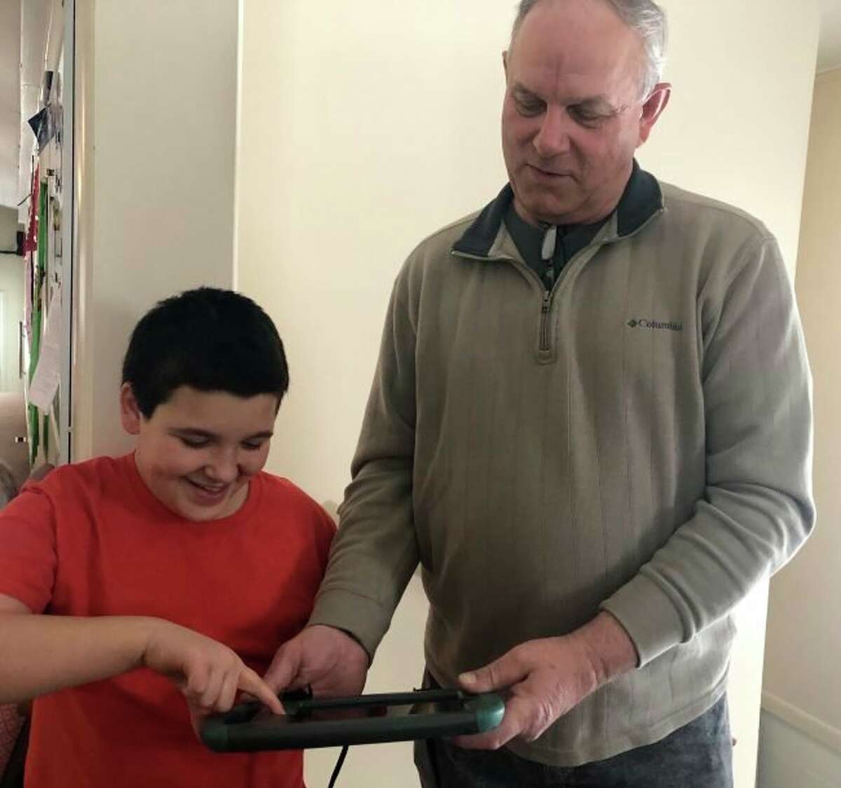 The Frankfort Lions Club helps raise money to purchase equipment needed by area residents, such as this communication pad purchased to help Frankfort resident Isaiah Borton (left) communicate. Also show is Gene Lentz, Frankfort Lions Club President. (Courtesy Photo)   