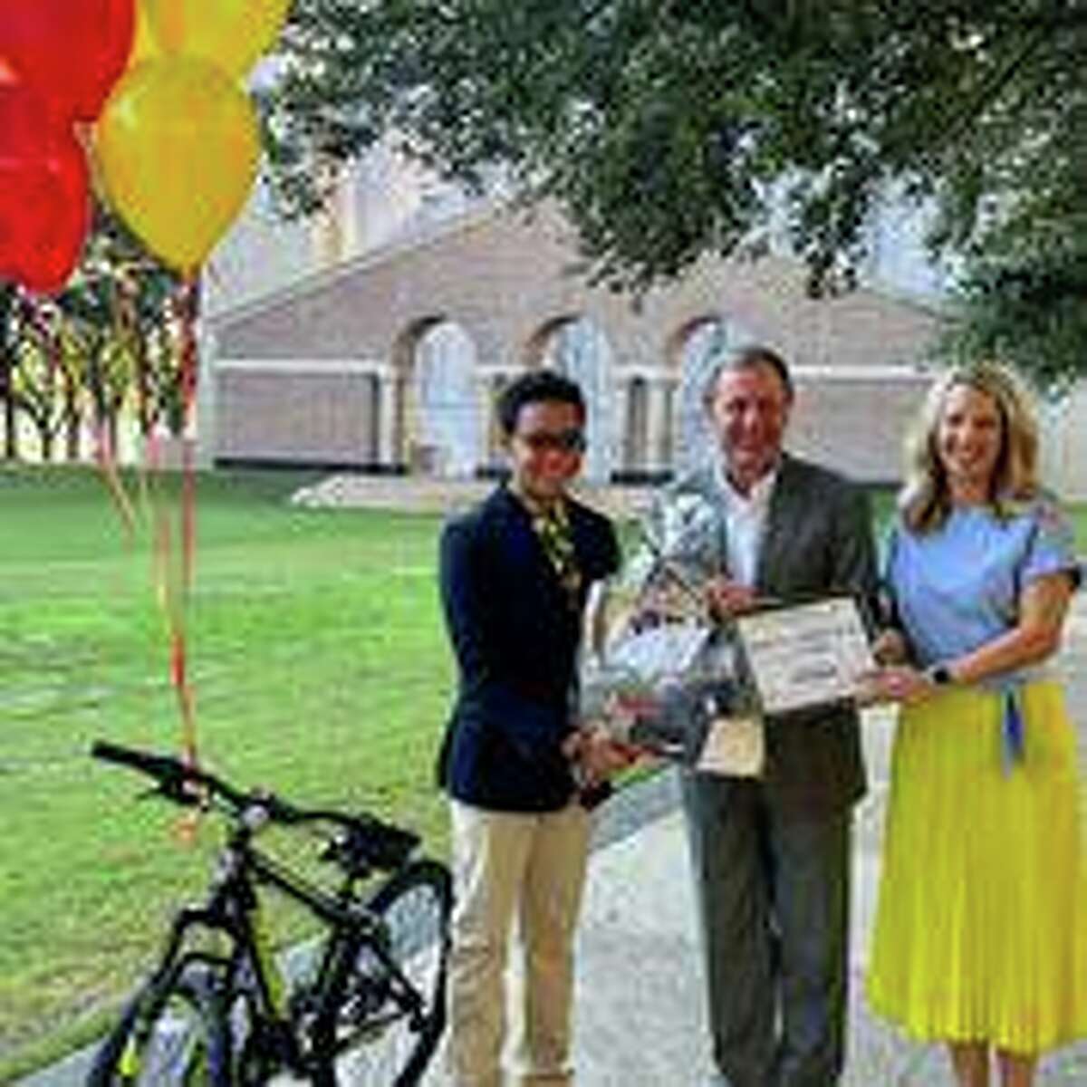 Sugar Land resident Myles Brown, left; Paul Murphy, chairman, chief executive officer and director of Cadence Bank; and Lemonade Day Houston Executive Director Bailey Kinney pose with the bicycle Myles received for being named the 2021 Lemonade Day Houston Youth Entrepreneur of the Year on Thursday, Oct. 7, in Houston.
